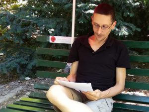 Jan-Christisn Petersen liest auf einer Parkbank im Rahmen eines Berliner Literaturfestivals.